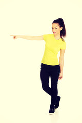 Young woman pointing aside.