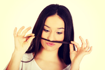 Teen woman putting hair like moustache.
