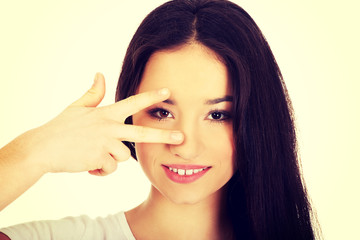 Obraz premium Young woman showing victory sign.