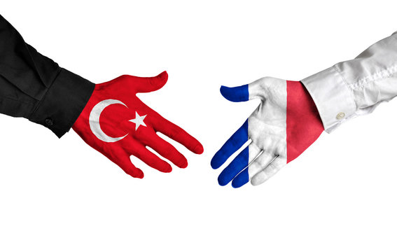 Turkey and France leaders shaking hands on a deal agreement