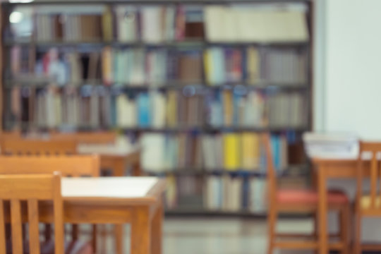 bookshelf and table desk in library, education abstract blur