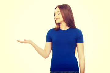 Smiling woman showing something on palm.