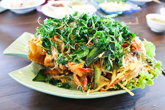 Deep fried fish with herb and spicy sauce, thai food.