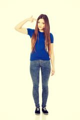 Fototapeta premium Despair teenage woman making gun sign.