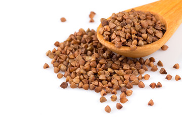 Uncooked buckwheat on wooden spoon