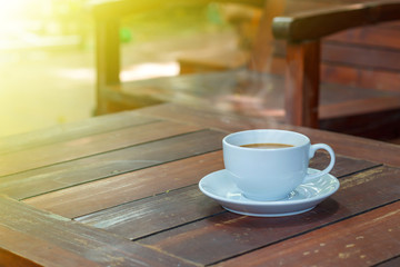 Cup of hot coffee  on wood board in morning