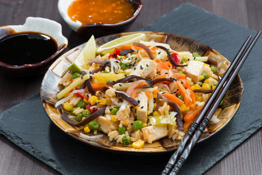fried rice with tofu, vegetables and sauces, close-up