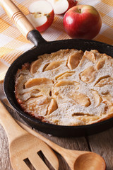 Dutch baby pancake with apples in a pan closeup. vertical
