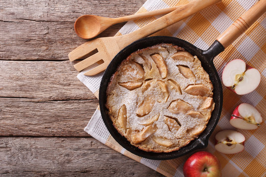 Dutch baby pancake in a frying pan with apples. horizontal top view
