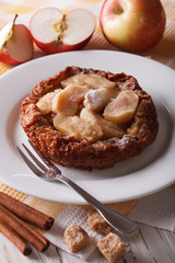 Dutch baby pancake with apples on a plate close-up vertical

