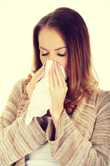 Sick woman blowing her nose.