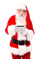 Old man in santa dress using tablet pc