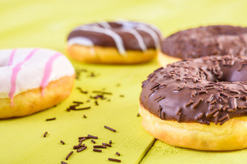 Chocolate Donuts On Yellow Wood Background