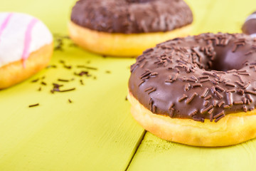 Chocolate Donuts On Yellow Wood Background