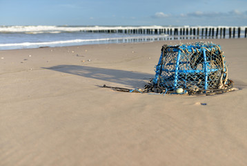 Fototapeta na wymiar panier pour crabe rejeté sur la plage