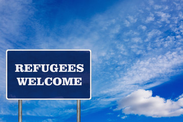 The road sign with Refugees welcome sign