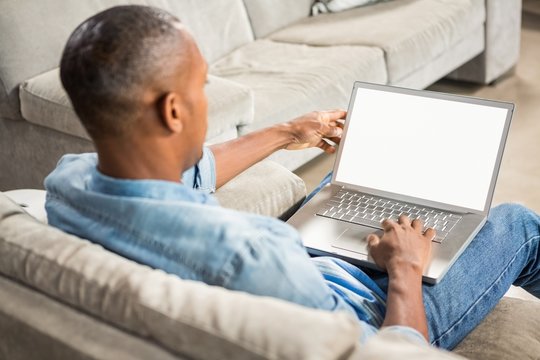 Over shoulder view of casual man using laptop
