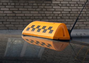 Taxi sign on car roof.