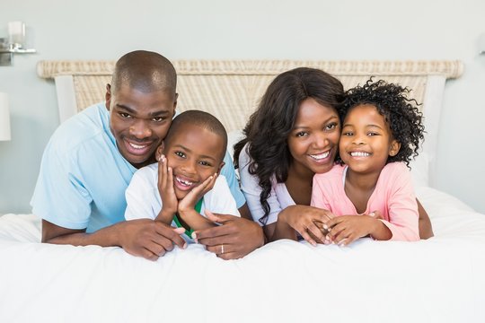 Happy family lying on bed