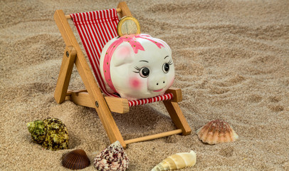Liegestuhl mit Sparschwein und Euro