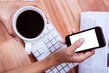 Businesswoman using her smartphone on desk