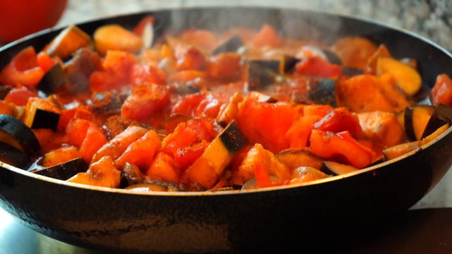 Healthy food lifestyle: beautiful woman casually cooking, stir, simmer vegetable in pan at kitchen. Close-up shot, handheld, slow motion 60 fps. 