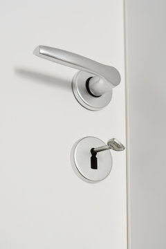 Close-up of a doorknob on white wood door