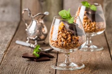 granola in glass with pieces of dark chocolate
