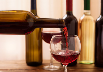 Red wine pouring into glass, close-up.