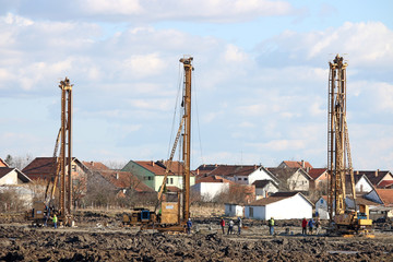 construction site with three hydraulic drilling machines and wor
