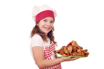 happy little girl cook with roasted chicken drumsticks