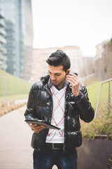 Fototapeta premium Young indian businessman usign technoligical devices