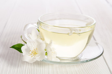 Obraz na płótnie Canvas Glass cup of tea with jasmine on the white background