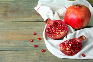 juicy pomegranate on white fabric on wooden background