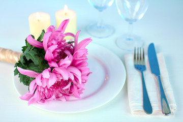 a bouquet of vivid flowers on the dining table with candles