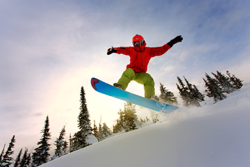 Snowboarder doing a toe side carve with deep blue sky in backgro