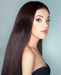 Young beautiful brunette woman with healthy long brown hair. Beauty haircare and hairdressing concept