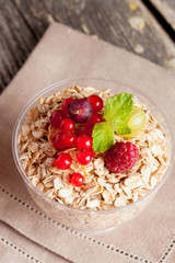 cereal and various berry for breakfast, close-up, vertical