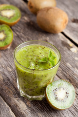 glass of kiwi juice with fresh fruits on wooden table