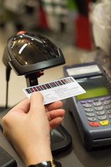 Cashier's hand scanning barcode on member card with credit card