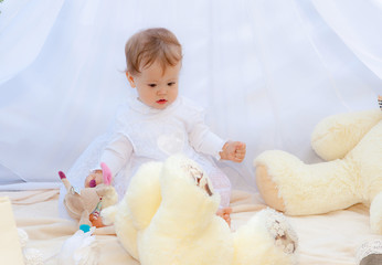 Baby playing in a park near the tents of baldachin © Andriy Petrenko