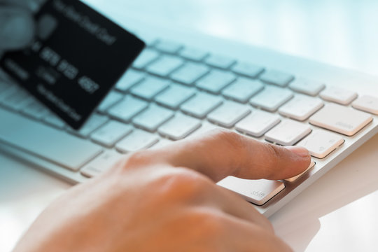 hand holding a credit card and typing. On-line shopping on the i
