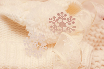Big white snowflake on white knitted scarf background.