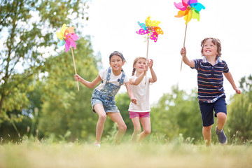 Gruppe Kinder spielt mit Windrädern
