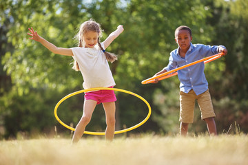 Junge und Mädchen mit Hula Hoop Reifen