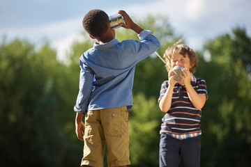 Zwei Jungen spielen mit Dosentelefon