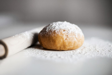Fresh dough, rolling pin and flour on the table, ready for baking