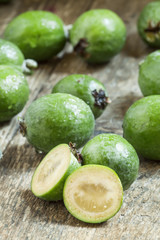 Slices of fresh pineapple guava at the old wooden table, selecti