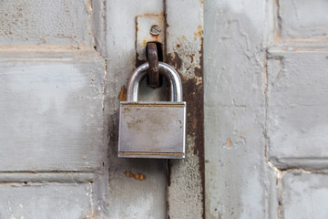 Old lock on wooden grungy painted door closeup.