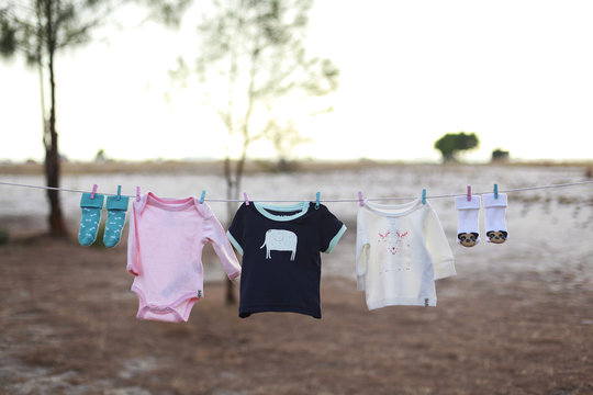 a pink and a baby blue T-shirt hanging on a clothesline on a bea